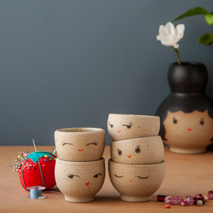 Two stacks of tiny bowls with various expressions