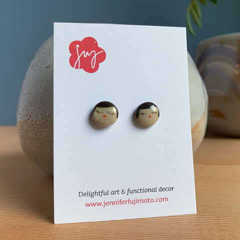 Ceramic earrings with cute peaceful expression on a backing card