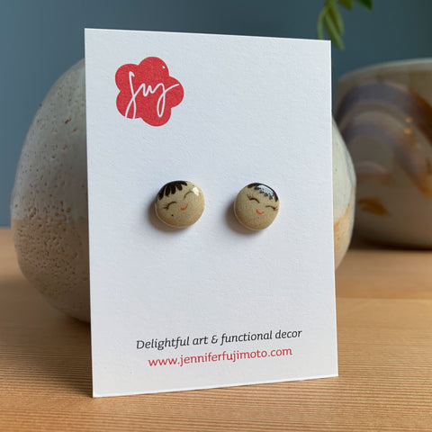 Ceramic earrings with cute faces on a backing card
